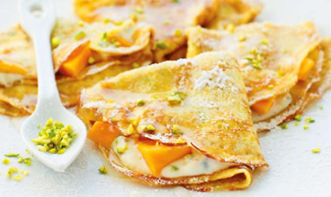 Ricotta-filled crêpes with mango and rose syrup